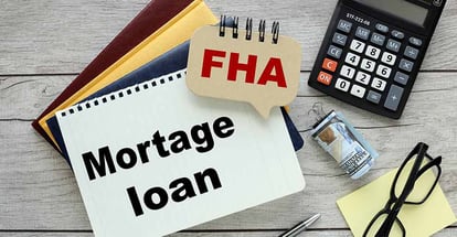 FHA loan text on a wood with notepads and calculator