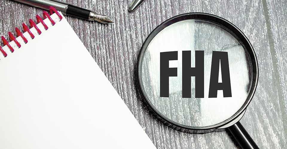 FHA loan word on a table with pen and magnifier