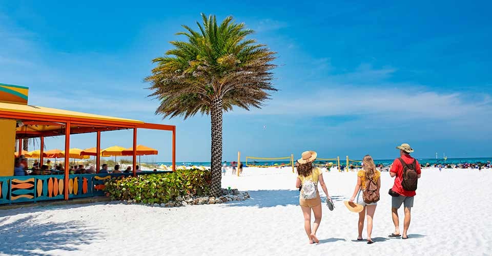 Family walking on beautiful white sand beach in Florida