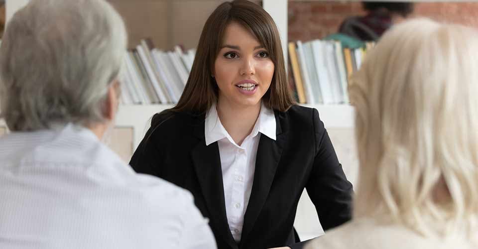Female loan officer talk with mature customers about mortgage