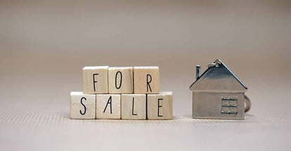For sale written on wooden cubes and model house