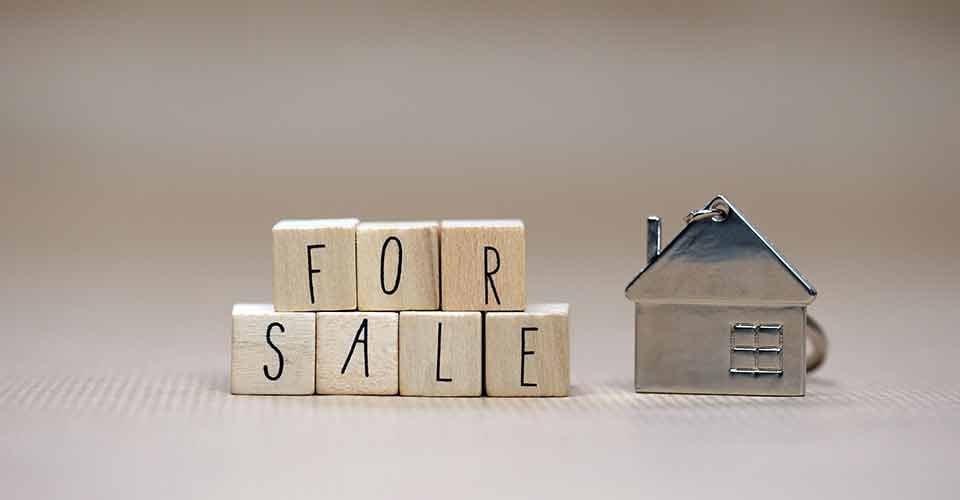For sale written on wooden cubes and model house
