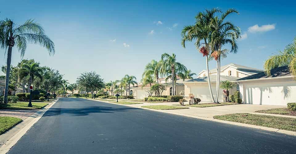 Gated community houses and empty asphalt road in South Florida