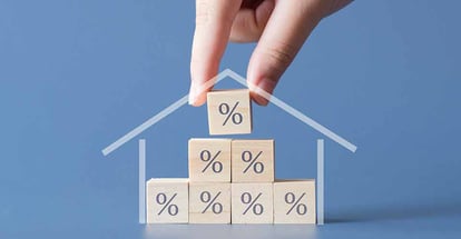 Hand building a house by wooden cube with the percentage sign on them
