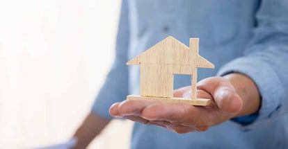Hand holding a wooden miniature home