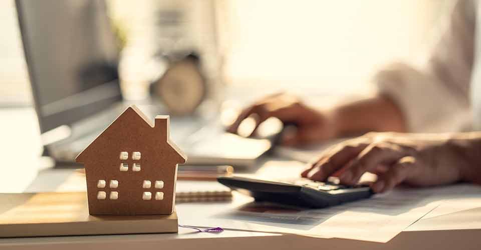 Hand of person calculating interest and profits to invest in real estate