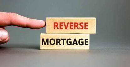 Hand pointing at reverse mortgage words on wooden blocks