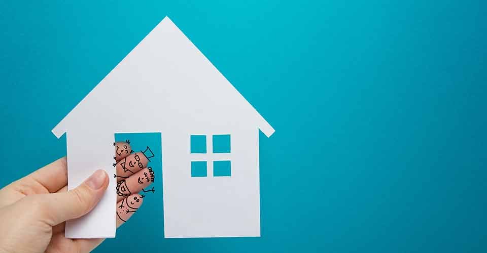 Hand with funny fingers holding white paper house