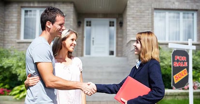 Happy Family and Realtor shaking hand outside new home