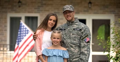 Happy american military family outside their home
