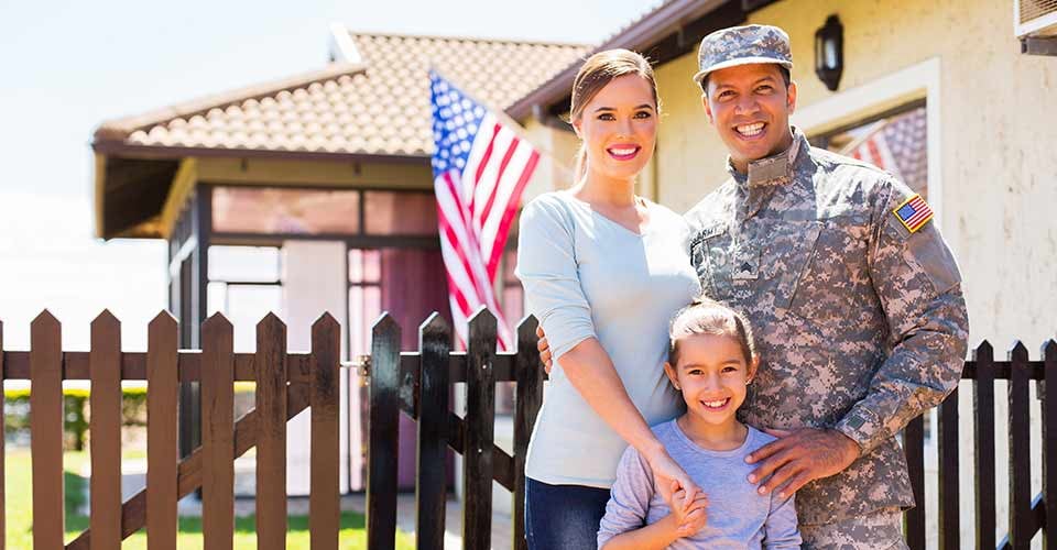 Happy american soldier reunited with family outside their new home