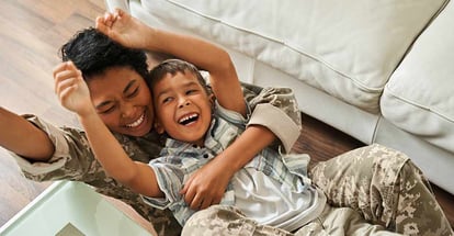 Happy black mother and her son playing on new home