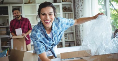 Happy couple unpacking cartons in their new house