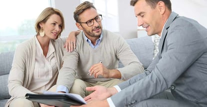 Happy couple with realtor signing mortgage contract