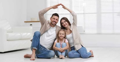 Happy family forming house roof with their hands at home