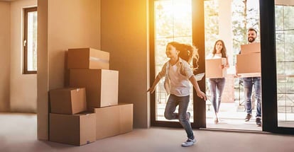 Happy family with cardboard boxes in new house at moving day