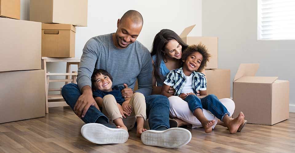 Happy family with children having fun at new home