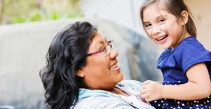 Happy latin mom and little daughter outside