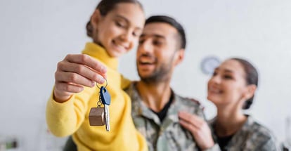 Happy parents in military uniform holding daughter with key at new home