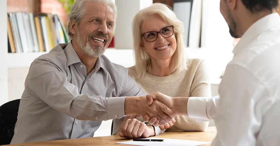 Happy senior couple handshake with loan officer after making real estate deal