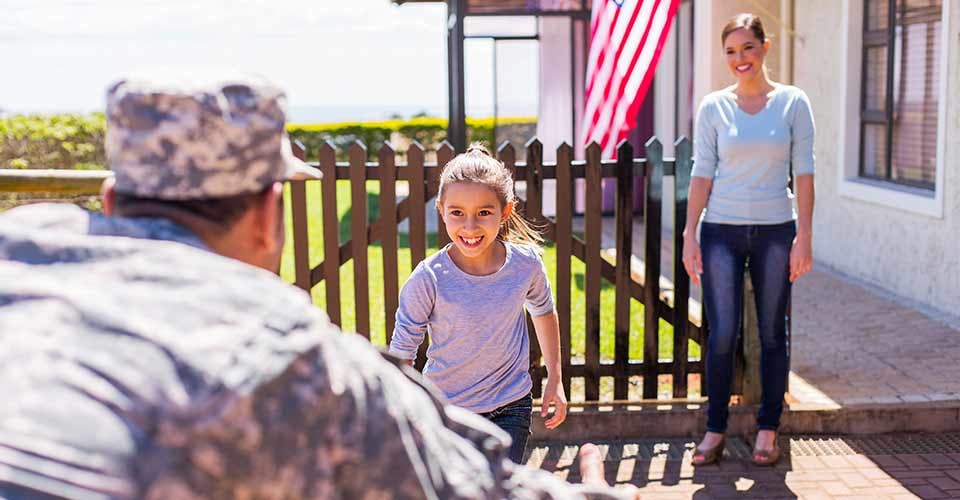 Happy young american military family outside their new home