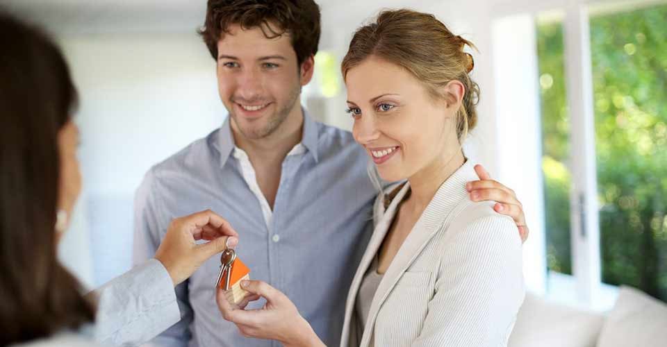 Happy young couple getting keys of their new home
