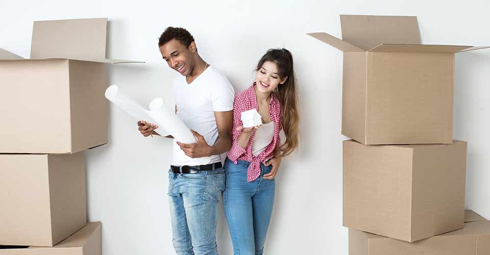 Happy young couple in a new house for housewarming