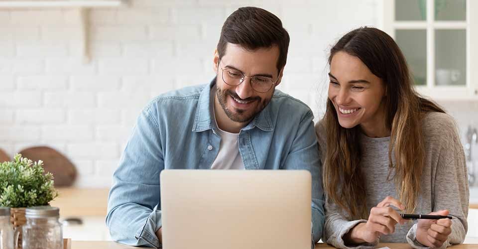 Happy young couple reading mortgage approval paper