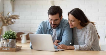 Happy young couple searching for home online