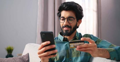 Happy young man searching for home loan on mobile
