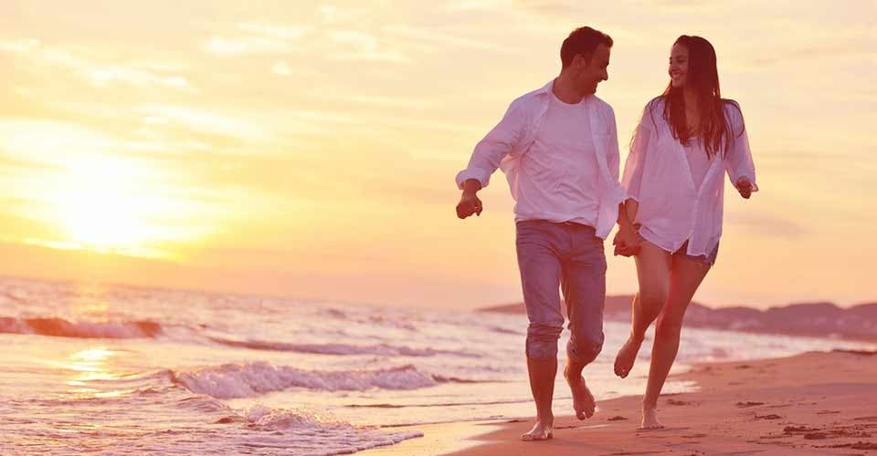 Happy young romantic couple in love have fun on beautiful beach in summer day