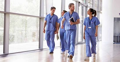 Healthcare workers in scrubs walking in corridor