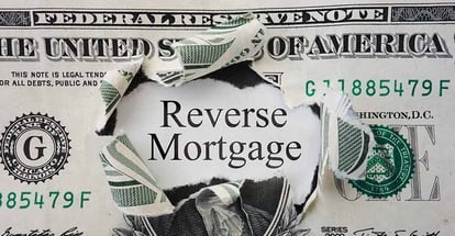 Hole torn in a dollar bill with Reverse Mortgage text