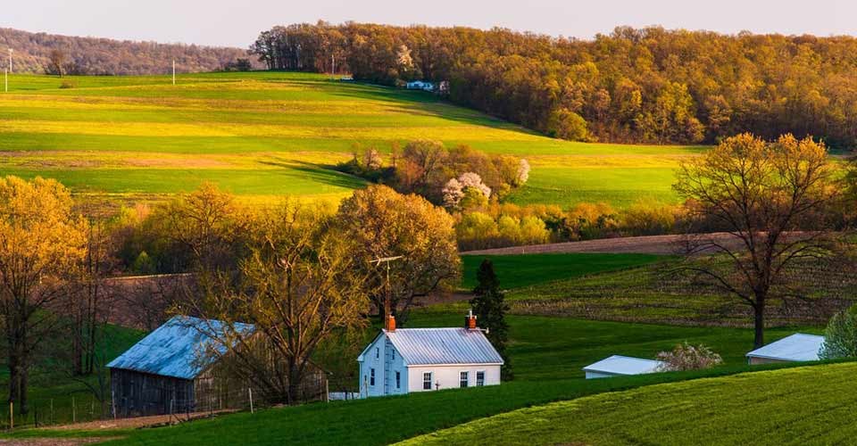Home and barn on the farm fields and rolling hills