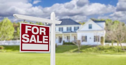 Home for Sale real estate sign in front of beautiful house