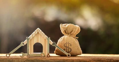 Home model with money bag and construction tools for renovation