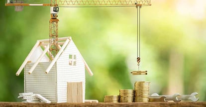 Home model with stack gold coin and tower crane for renovation