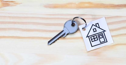 House Symbol with Silver Key on Wooden Table
