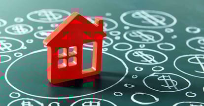 House model and painted dollar symbols on chalkboard