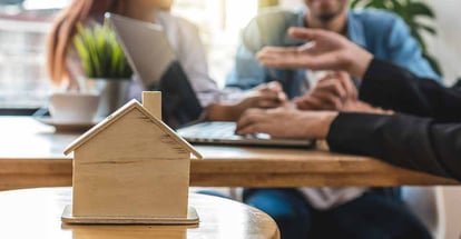 House model and real estate agent talking with buyer about home purchase