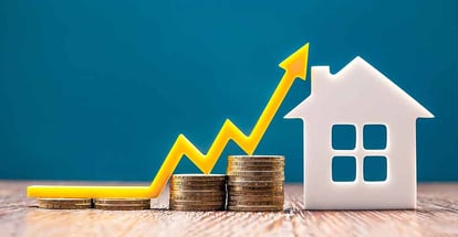 House model and stack of coins with up arrow