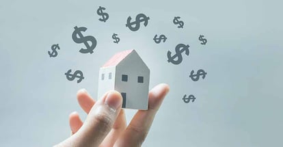 House model on human hands with dollar icon