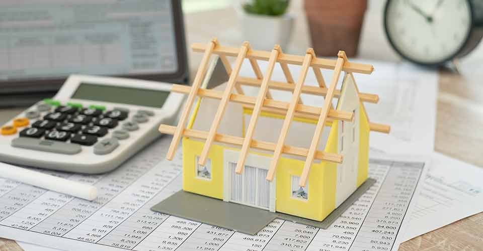 House model on the table with calculator and home renovation document