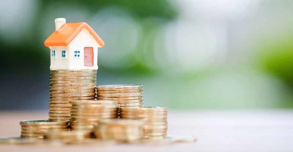 House model on top of stack of coins