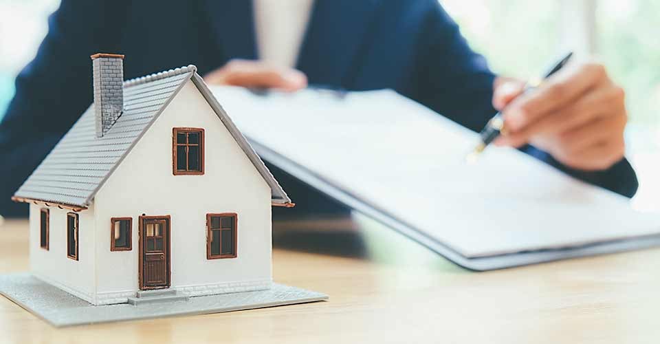 House model with real estate agent and customer discussing contract to buy house