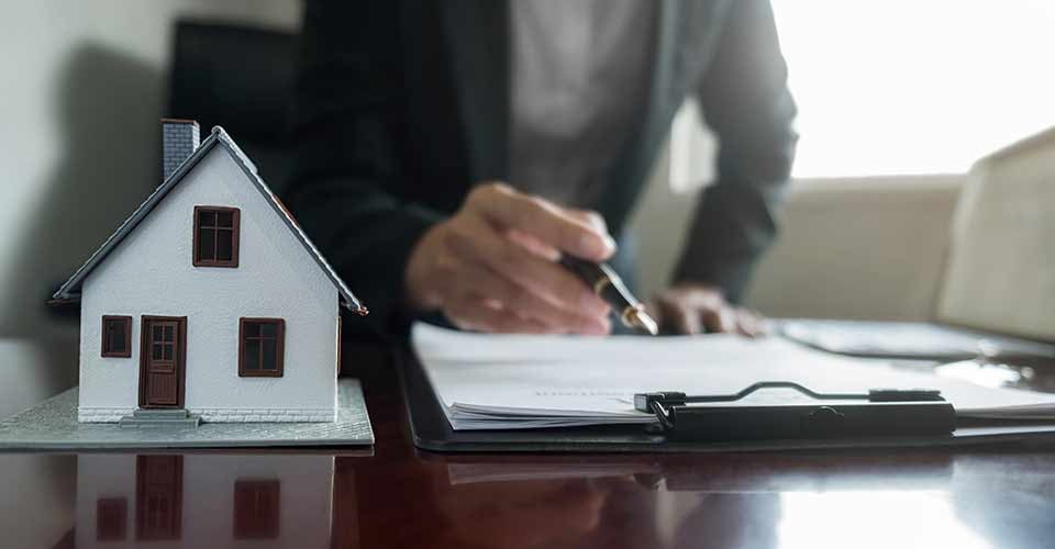 House model with real estate agent and customer discussing for contract to buy house