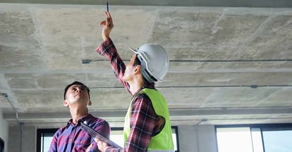 Inspector is checking with checklist and pointing new building with customer