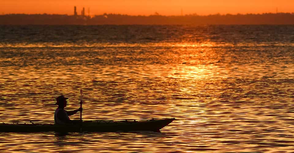 Kayaking at sunrise on a bay in north Florida with beautiful golden light on the water