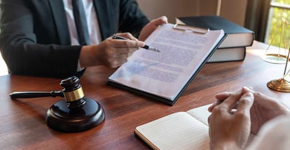 Lawyer discussing contract papers with client in office
