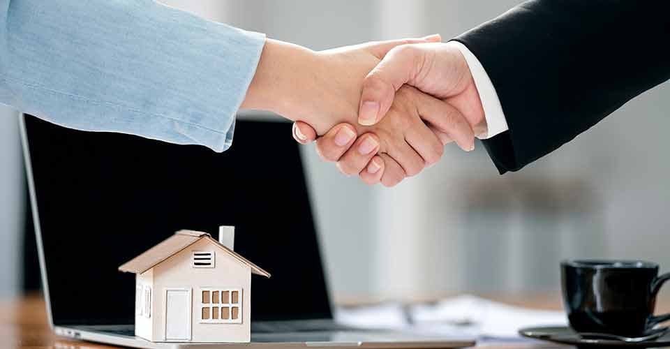 Loan officer and customer shaking hands after signing a contract